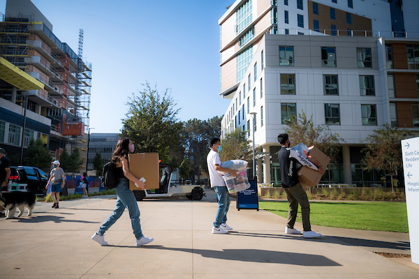 Photo of students carrying boxes as they move into campus