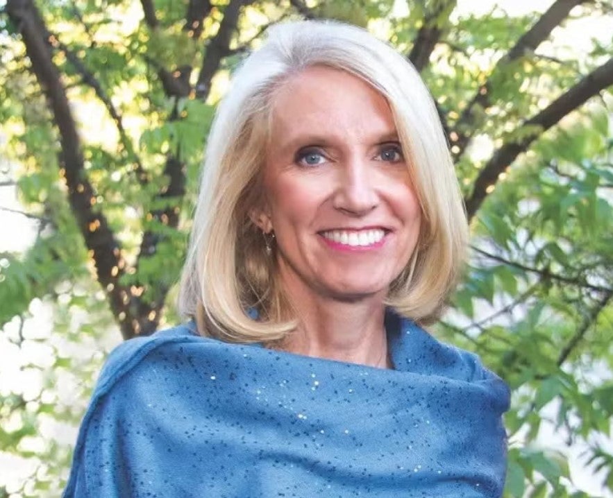 Photo of Kari Nadeau, MD, PhD, dean of the UCLA Fielding School of Public Health, in front of a tree wearing and dressed in blue