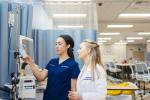 Simulated training between a student and faculty in a white coat