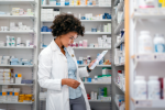 pharmacist in a white coat looking down at medications