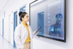 Image of a healthcare provider in a white coat looking at a screen with diagrams