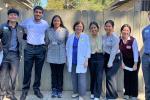 Eight student volunteers with Bayanihan Clinic pose for the camera with ophthalmologist Barbara J. Arnold in the center