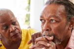  Woman, left, looks at man in a concerned fashion with her hand on his shoulder while he stares off into the distance with hands clasped below his chi