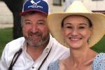 Man wearing baseball hat and woman with blue dress and hat