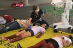 Doctor kneeling over patient laying down and performing ultrasound on their stomach