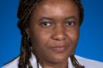 Imo Ebong wearing a white lab coat