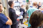 Doctors and nurses standing around patient bed in emergency department
