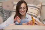 Emily looking down at baby Robbie laying on a pillow