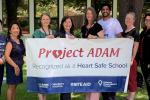 District nurses hold Heart Safe Schools banner