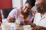 Woman at table with father eating fruit