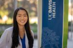 Jade Tso stands next to the UC Davis School of Medicine banner on the Sacramento campus