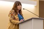 Kim Barrett stands at podium
