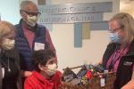 Bassem Mansour and family presenting basket of gifts to child life specialist Jenny Belke