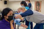 Cristo Rey High School student Jacqueline Castañeda receives COVID-19 vaccine in her arm from a medical student
