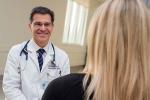 Doctor Martin Cadeiras wearing a white coat speaking with a patient 