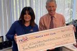 Tami Emslie and Dean Blumberg hold check