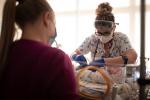 NICU nurse caring for a baby while mom watches