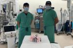 Doctors Phan and Godoy wearing green scrubs and mask standing in operating room