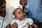 A woman holds a baby on her lap at the University Teaching Hospital – Eye Hospital in Lusaka, Zambia. 