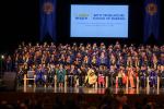 Stage full of seated nursing graduates and faculty