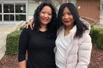 Two women standing arm-in-arm with each other