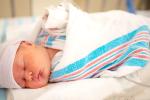 Baby laying wrapped up in a blanket