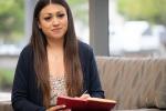 Veronica Neri, Pediatric and family navigator, writing in a notepad