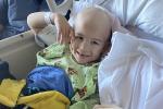 Boy in hospital gown lying on bed