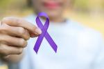 Woman holding purple ribbon representing Alzheimer’s and Brain Awareness Month in June. 