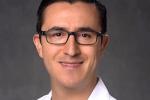 Man with dark hair, glasses and white lab coat.