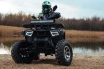 Young child riding a quad in a forest
