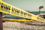 Crime scene tape stretched across a California beach.