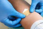 nurse putting on a bandaid after person gave blood