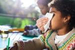 Adult helping a school child blow their nose