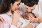 mom breastfeeding with dad kissing top of baby's head