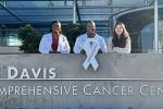 Wide shot of Dr. Cooke w/ group of students and white ribbon.