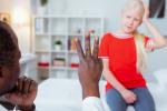 Doctor raising three fingers to diagnose girl with concussion 