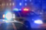 Blurry photo of police cars in urban environment with flashers on