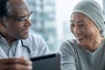 Male doctor and female patient looking at a tablet