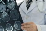 Doctor with a stethescope holding MRI brain scans