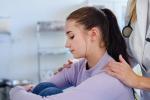 Doctor consoling unhappy teenage girl