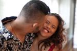 A young man with Down syndrome kisses his girlfriend, who also has Down syndrome. 