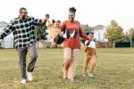 A mom, dad and two children play together outside.