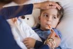 Boy in bed with thermometer in mouth