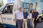 5 people stand in front of the van. 