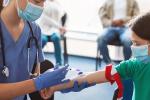 Young girl wearing a facemask and medical tourniquet for blood draw