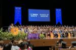 Class of 2025 graduates on stage with audience facing them.