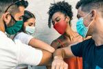 masked people greeting each other with elbow bumps
