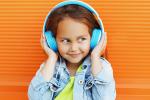 Smiling young girl wearing headphones listening to music