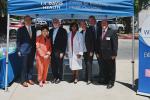 Four men and three women stand shoulder-to-shoulder under blue pop-up tent that states, “Center for Reducing Health Disparities”